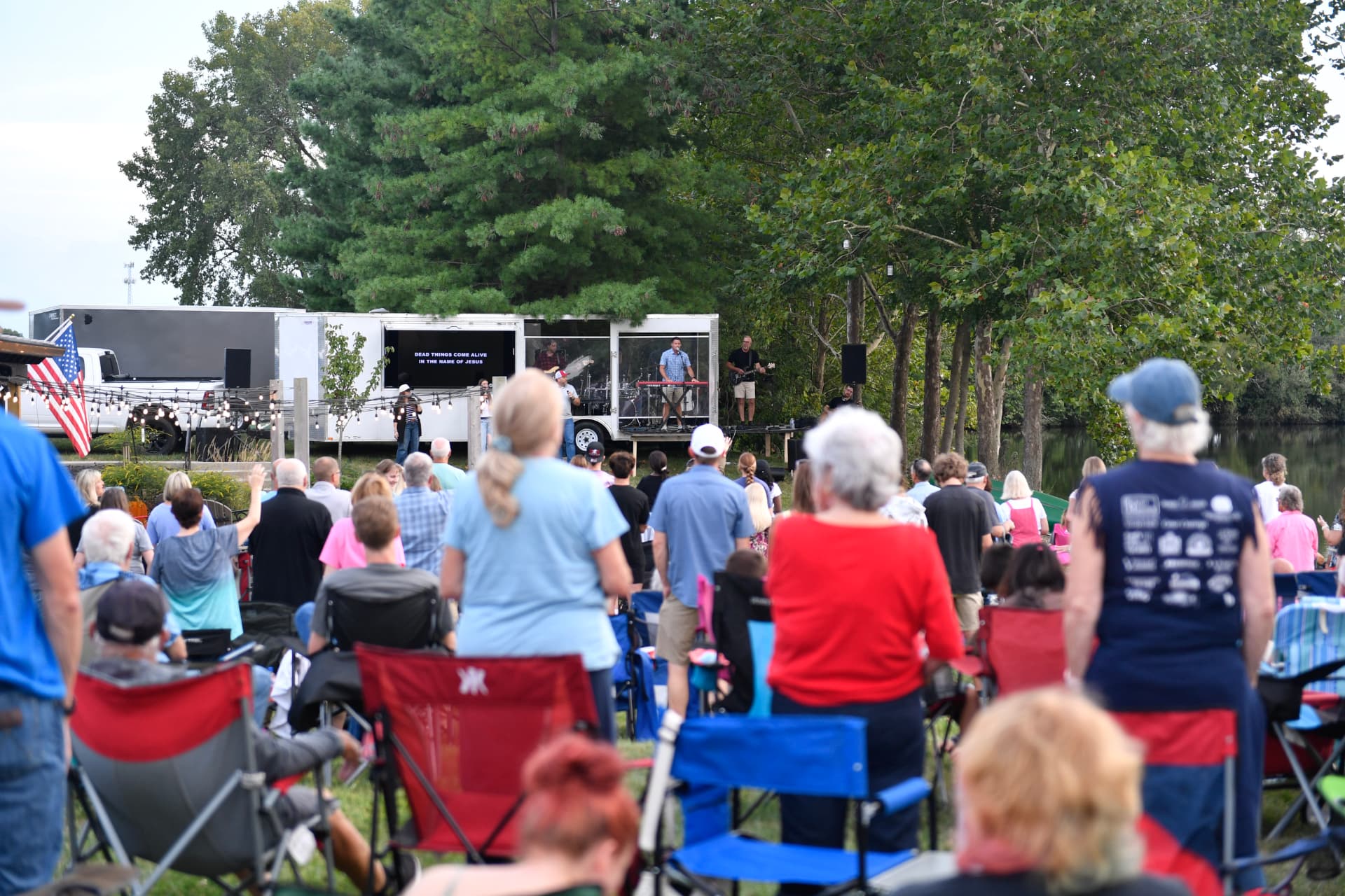Crowd gathered at an outdoor Cowboy Church service by the lake